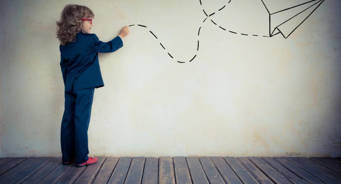 Niño lanzando avión de papel pintado en la pared